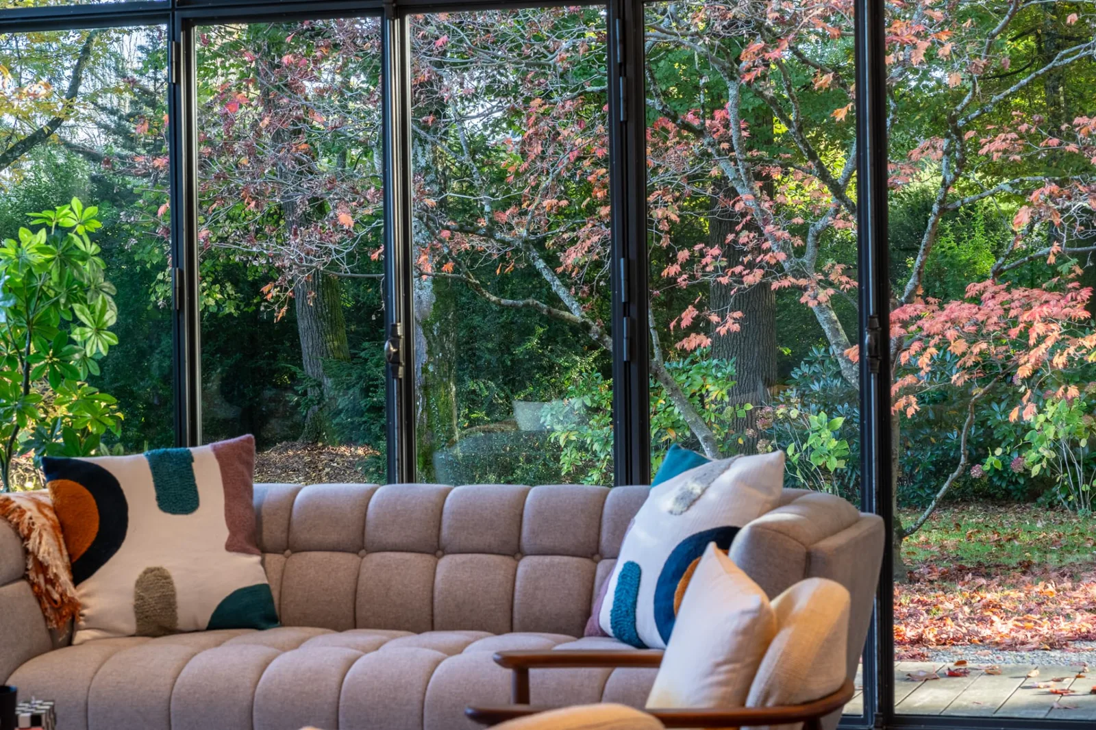 Living room opening onto a garden with autumn foliage
